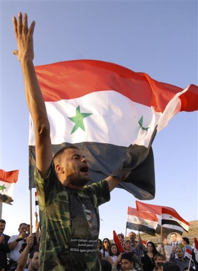 A pro-Assad protester shouts slogans during a motorcade protest to show support for his president, in Damascus, Syria, on Tuesday July 7, 2011.
